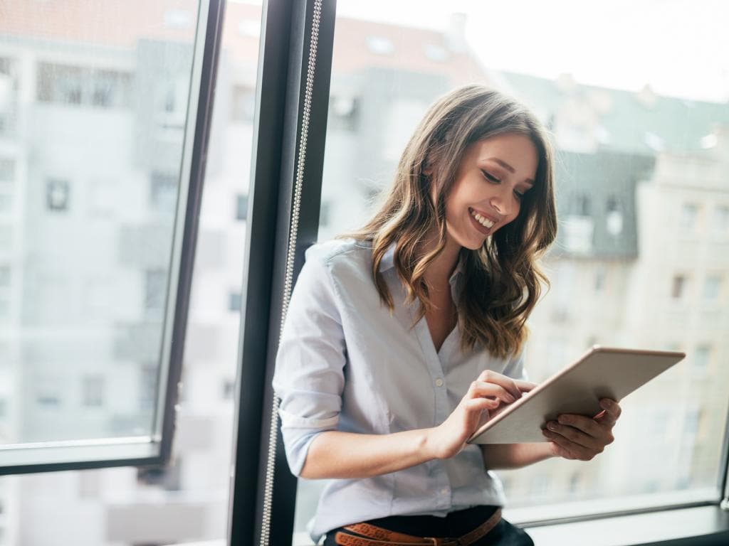 Woman looking at tablet smiling L