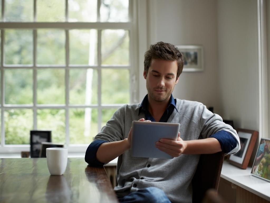 Person sitting in kitchen with tablet L